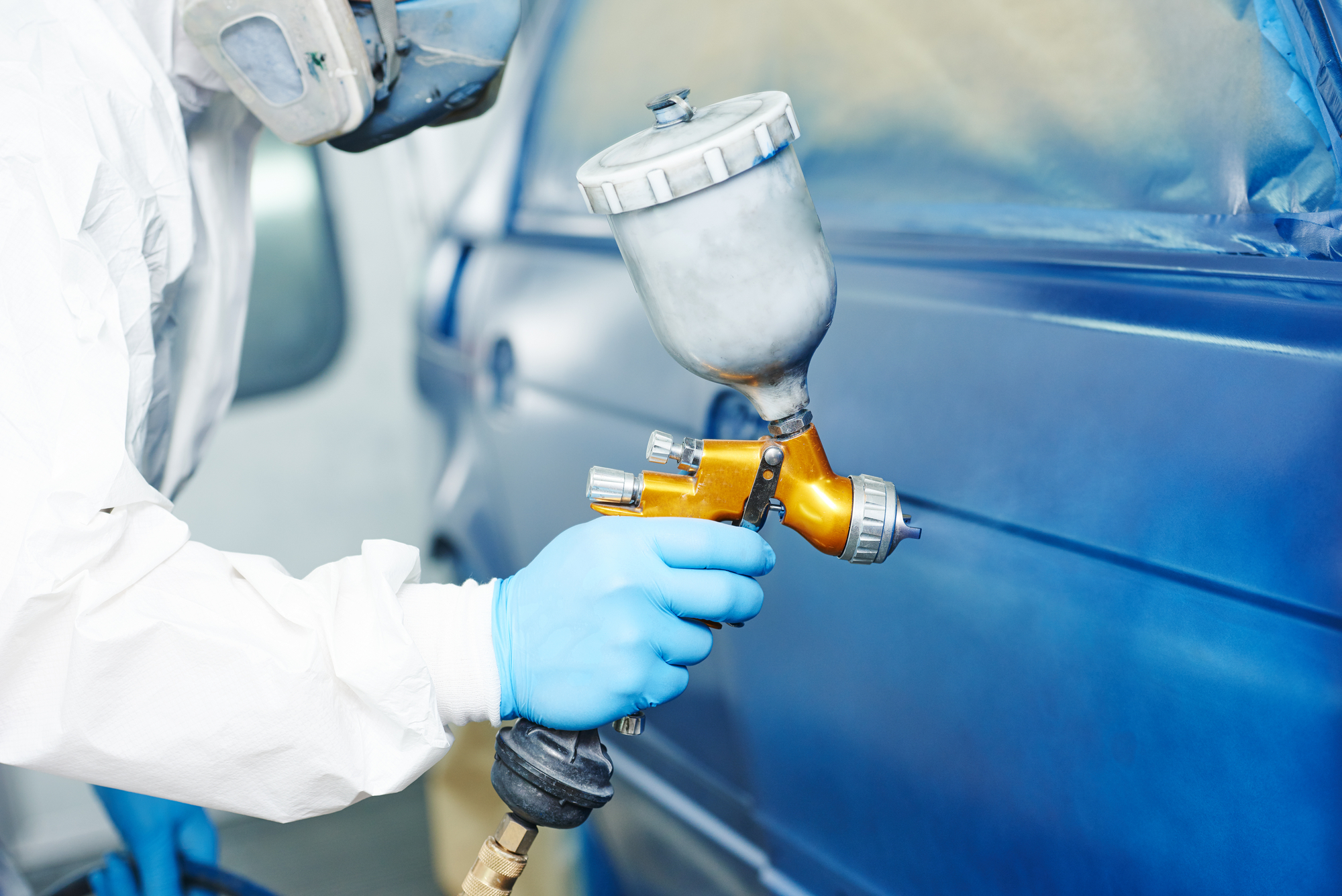 Technician spray painting the car